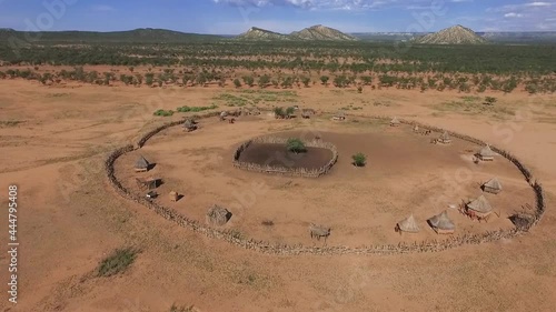 Beautiful aerial footage over a round Himba African tribal settlement and family compound in northern Namibia, Africa. Typical himba village in the bush far away from a city. photo