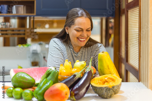 woman in the kitchen with fruint and vegetables photo