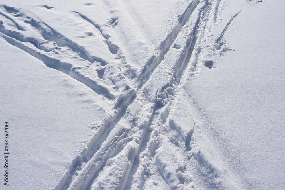 Ski tracks on white snow, top view.