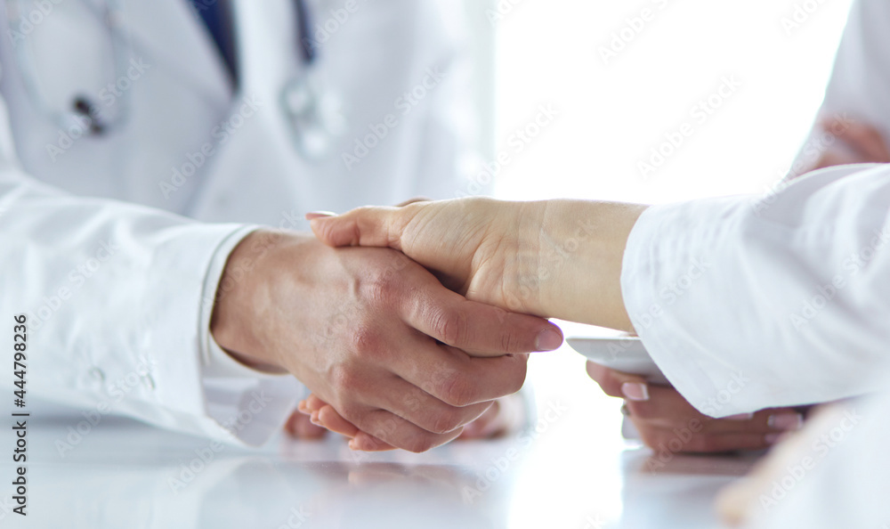 Doctor shaking hands with a male patient in the office