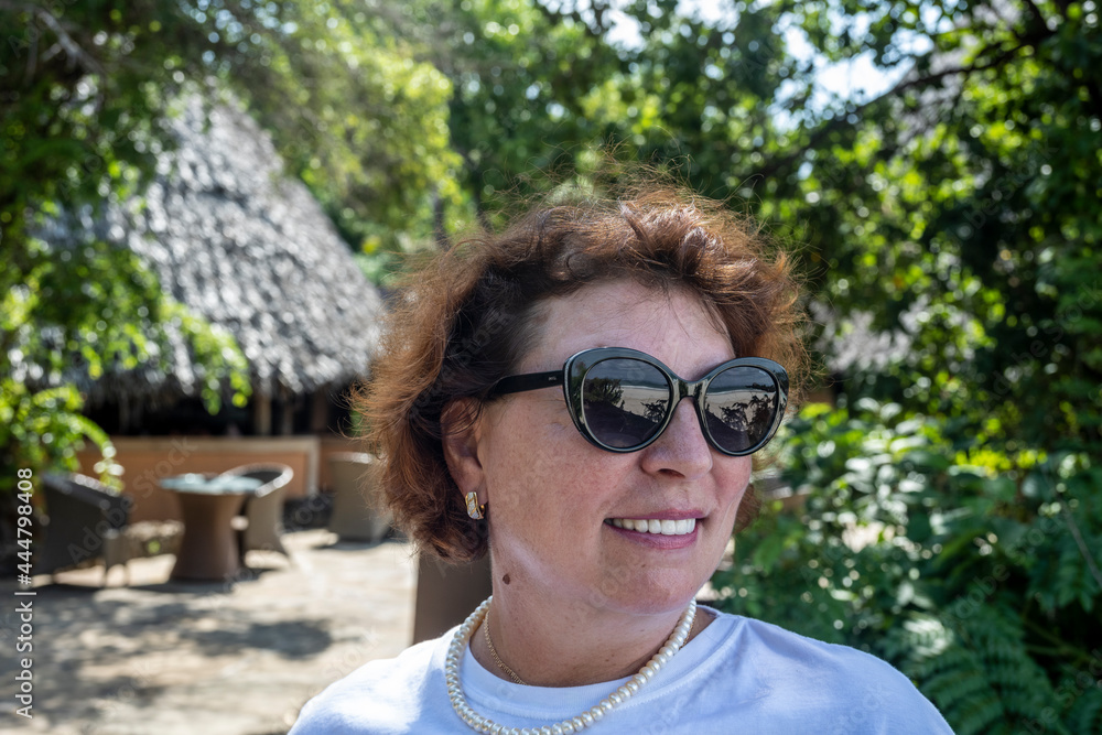 woman portrait in black glasses which reflects the beach and the sea woman portrait in black glasses which reflects the beach and the sea