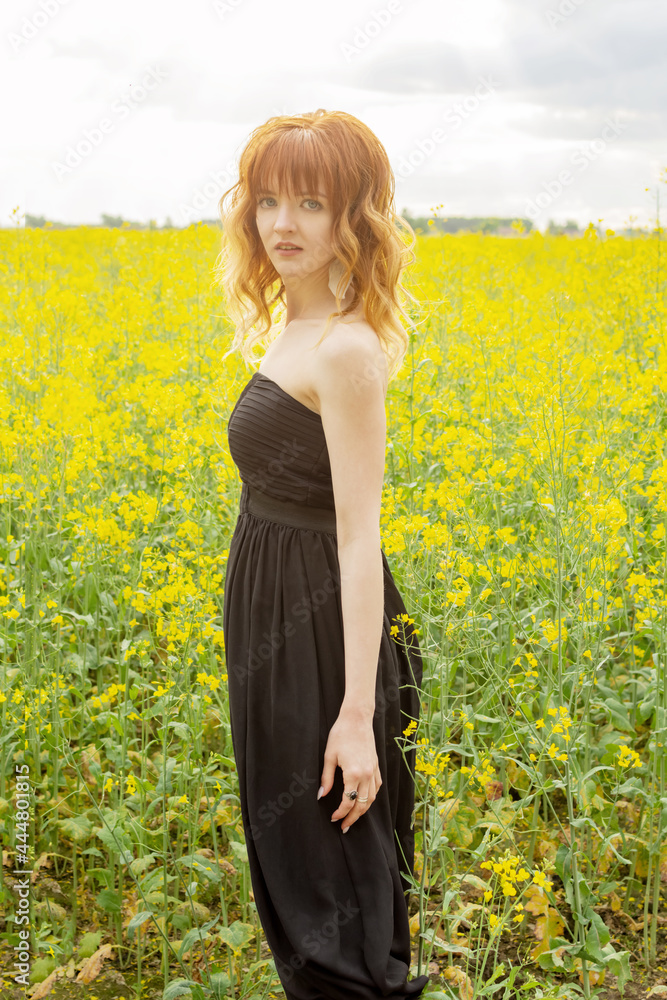 Redhead girl in a rapeseed field at sunset... Redhead girl in a rapeseed field at sunset...