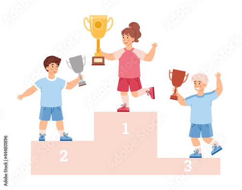 Children winners with gold, silver and bronze trophy award cups stand on podium.