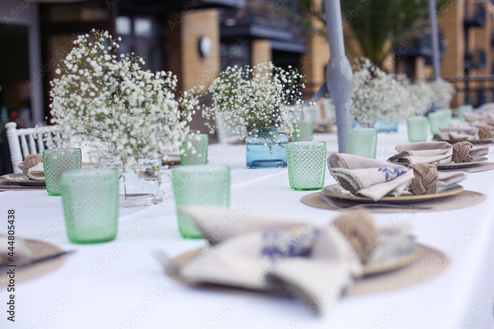 Table setting at a wedding or party outside with flowers and glassware
