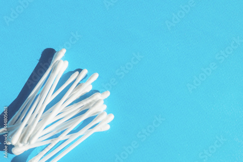 Heap of cotton sticks on blue background  hygienic cosmetic and healthcare accessory