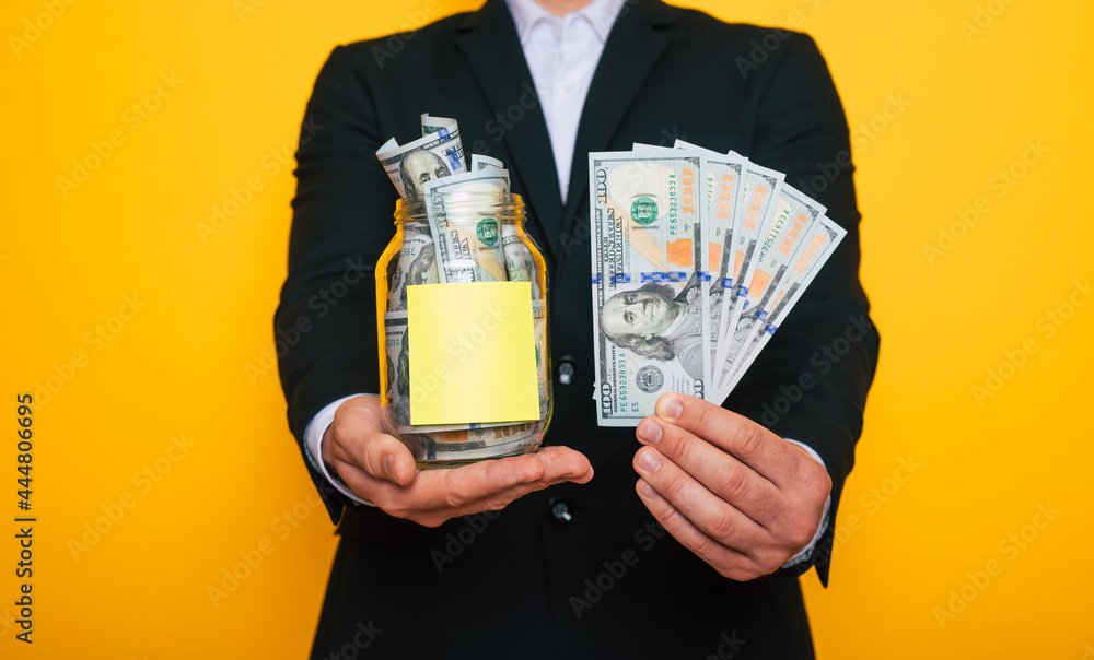 Full transparent bank with dollar savings isolated on yellow background Full transparent bank with dollar savings isolated on yellow background