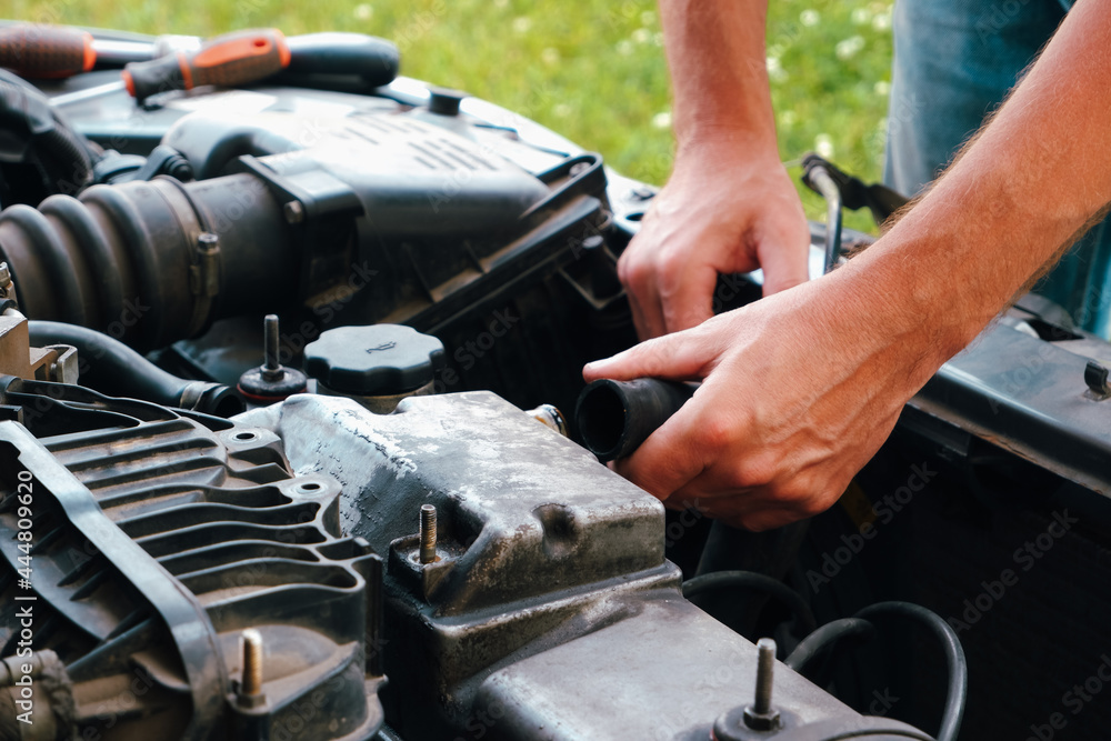Car repair. Auto mechanic working on car engine in mechanics garage. Repair service. Close up of car mechanic repairer technician repairs auto engine Car repair. Auto mechanic working on car engine in mechanics garage. Repair service. Close up of car mechanic repairer technician repairs auto engine