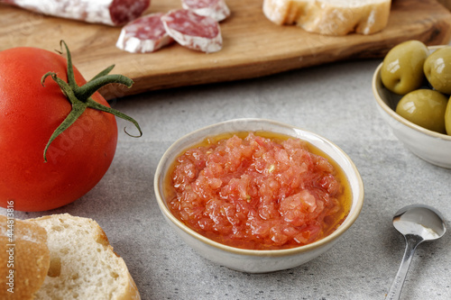 Grated tomato with olive oil in bowl. Catalan typical paste to make bread with tomato (Pa amb tomaquet). photo