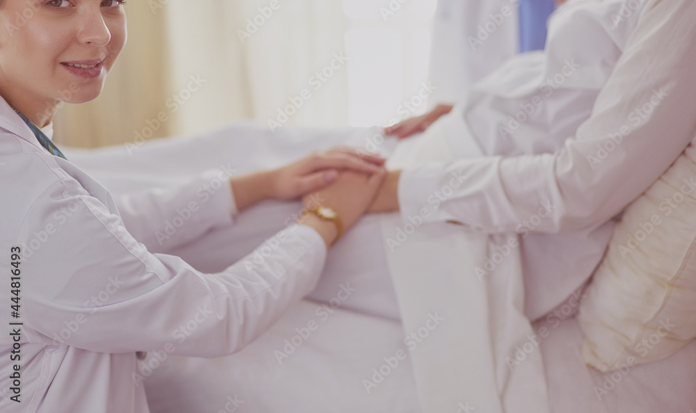 Obraz premium Doctors and nurses stacking hands. Isolated on white