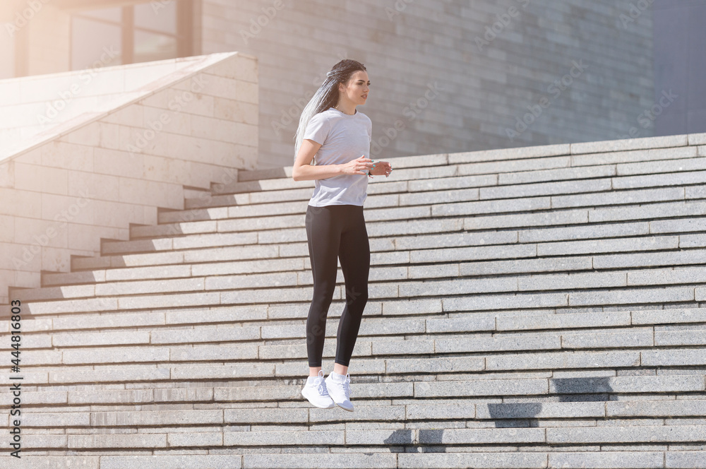 Fitness girl jumping on stairs during her morning workout. Urban sport concept Fitness girl jumping on stairs during her morning workout. Urban sport concept