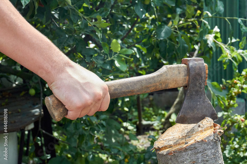 Close-up yog hand with axe cutting a log. photo