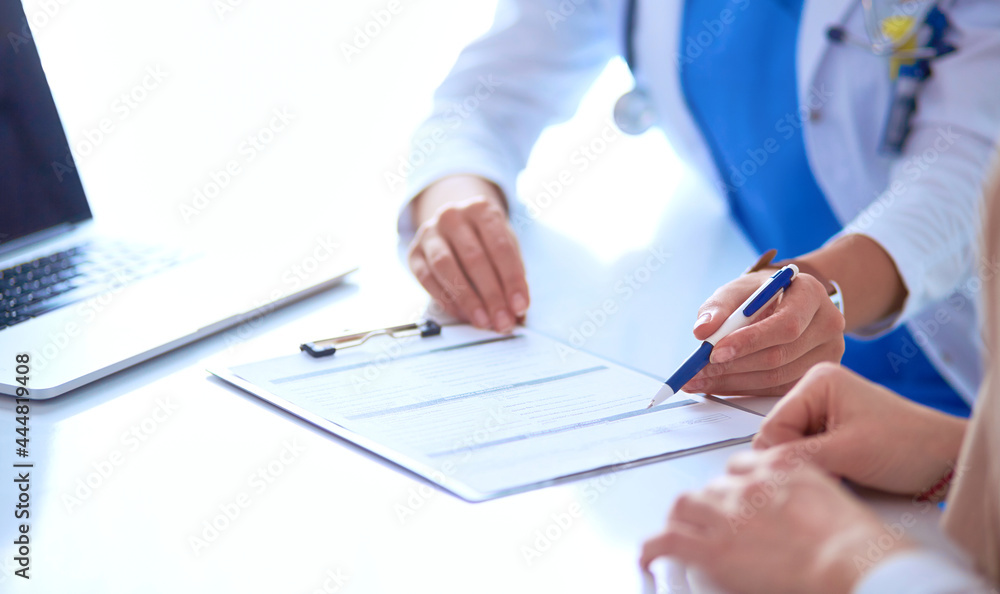 Doctor and patient couple are discussing something,sitting on the desk Doctor and patient couple are discussing something,sitting on the desk