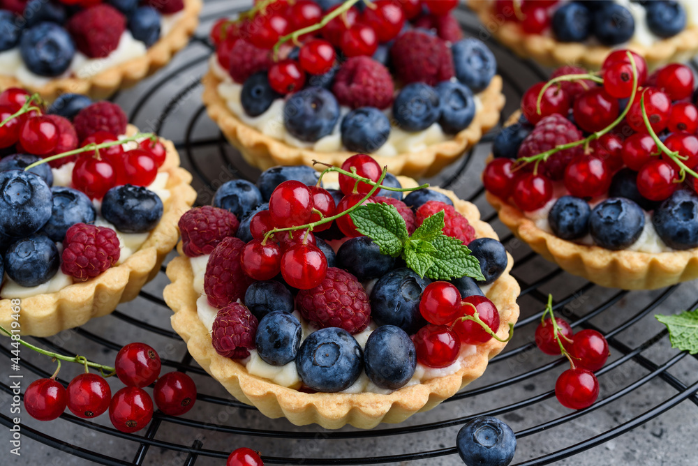Tartlets with curd cream and fresh berries of raspberries, blueberries, red currants. Summer fruit baking. Close-up. Selective focus Tartlets with curd cream and fresh berries of raspberries, blueberries, red currants. Summer fruit baking. Close-up. Selective focus