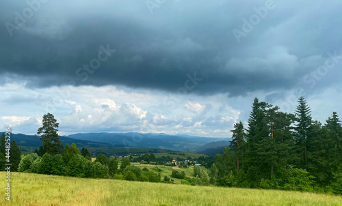 landscape with green grass and mountains, Małopolska, dark clouds