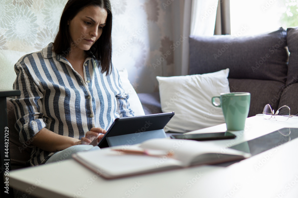 Caucasian white young woman working from home with a digital tablet Caucasian white young woman working from home with a digital tablet