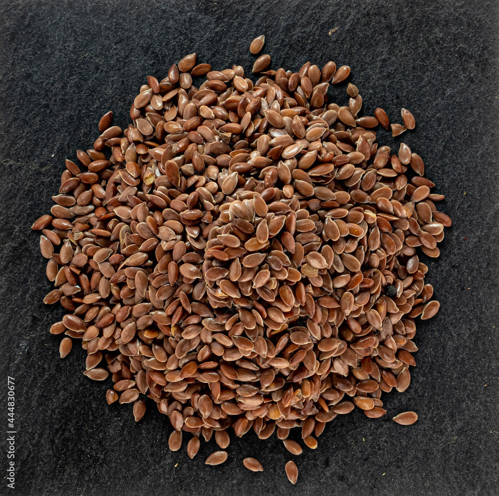 flax seeds on a black stone subdice, macro photography flax seeds on a black stone subdice, macro photography