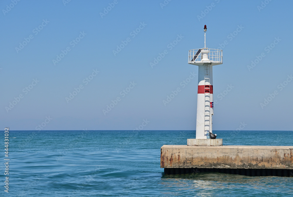A lighthouse at the end of a long reinforced concrete pier