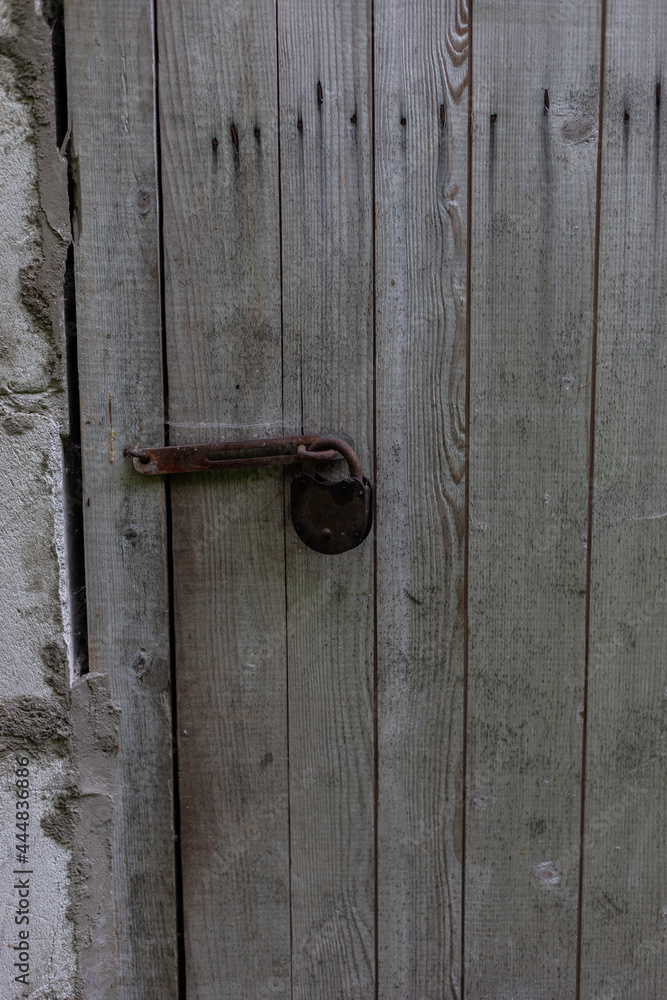 wooden brown, grey old door with ancient, old, rusty lock. close up. Background for design and presentations. wooden brown, grey old door with ancient, old, rusty lock. close up. Background for design and presentations.
