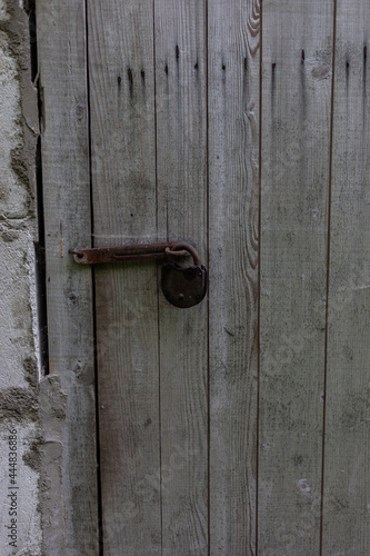 wooden brown, grey old door with ancient, old, rusty lock. close up. Background for design and presentations.
