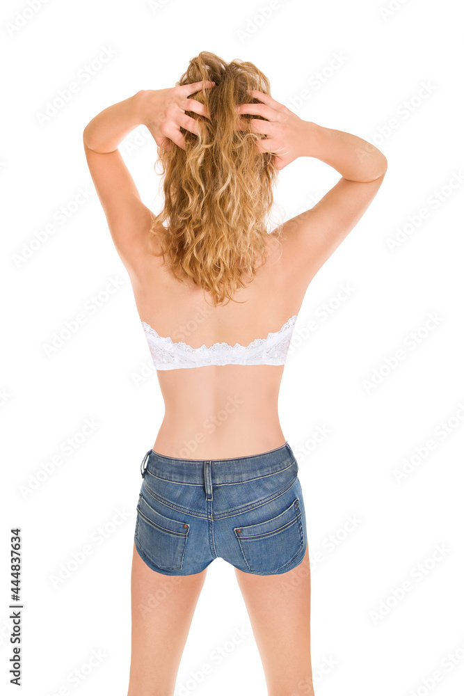 Closuep rear view of an attractive blonde woman wearing short blue jeans and a bra, isolated on white studio background Closuep rear view of an attractive blonde woman wearing short blue jeans and a bra, isolated on white studio background