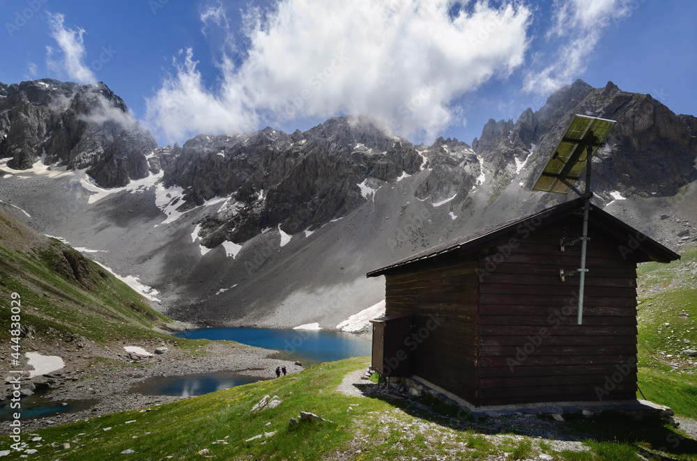 Apsoi lake, mountain lake and nearby wooden bivouac on the path to colle delle muine (pass of muine) in maira valley, beautiful landscape in the maritime alps of Piedmont, Italy