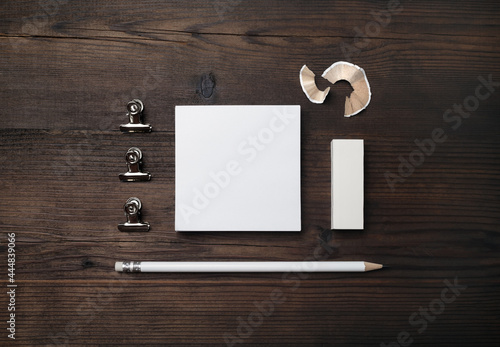 Blank notes, pencil and eraser on wood table background. Stationery mockup. Objects for placing your design. Flat lay.