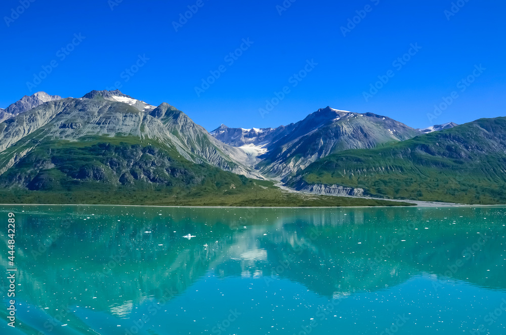 Alaska landscape mountains and water, sunny day, blue sky. Mountains reflection in the water. Remote location, unplugged. Wild beauty in nature. Untouched environment