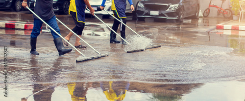 Foto Selective focus to worker using wiper or squeegee to clean floor surface