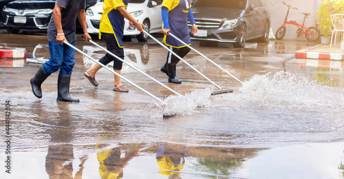Selective focus to worker using wiper or squeegee to clean floor surface. Staff cleaning floor with wiper. The concept of cleaning service. photo