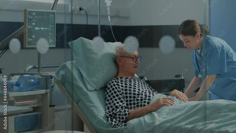 Nurse and african american doctor tending to ill patient in hospital ...