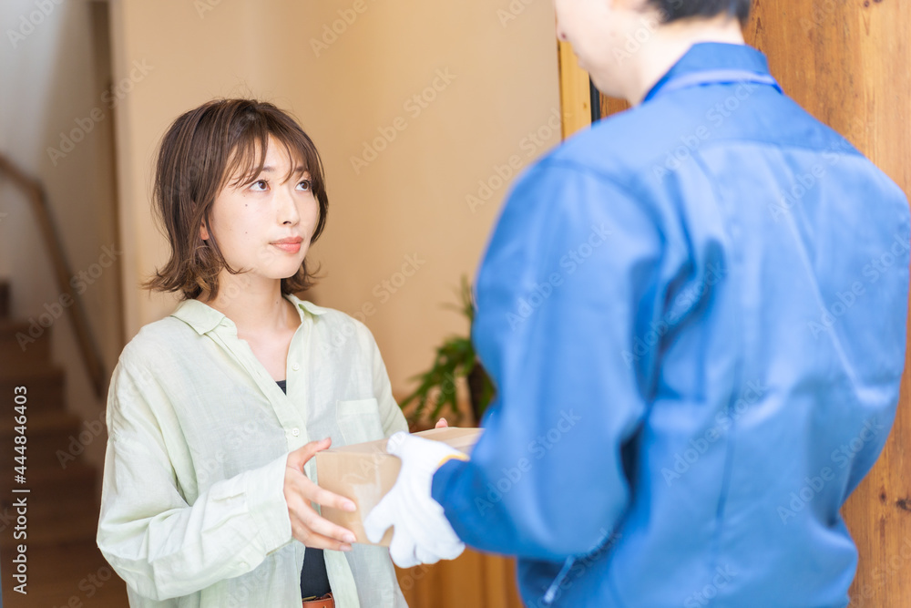 宅配便・デリバリーを受け取る若い女性 宅配便・デリバリーを受け取る若い女性