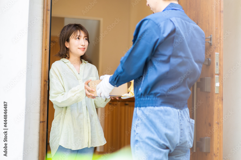 宅配便・デリバリーを受け取る若い女性 宅配便・デリバリーを受け取る若い女性