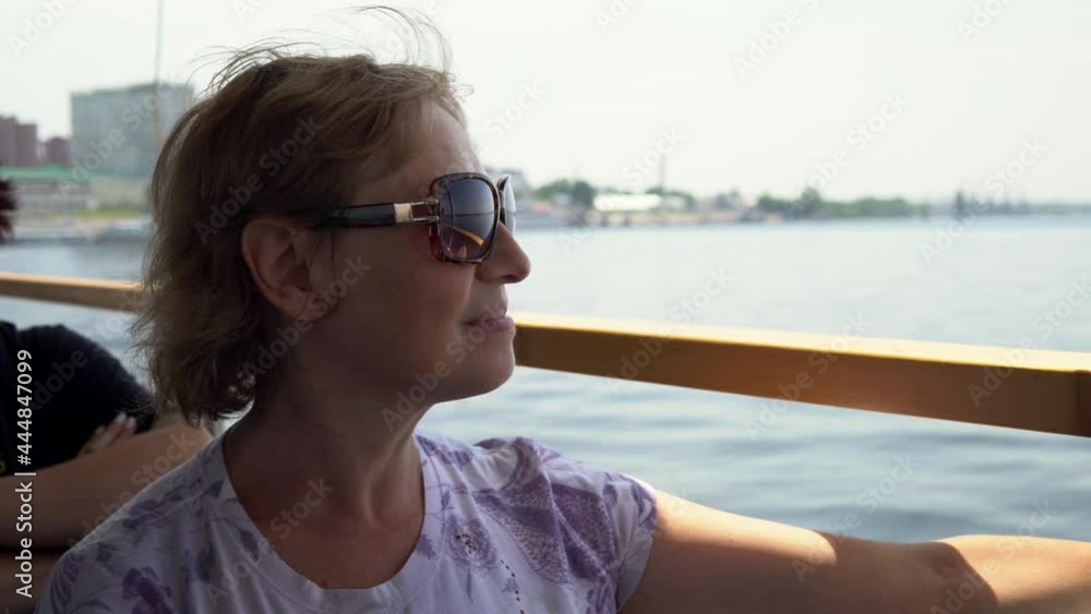 A woman on board a ferry is crossing the river. Boat trip down the river 4k A woman on board a ferry is crossing the river. Boat trip down the river 4k