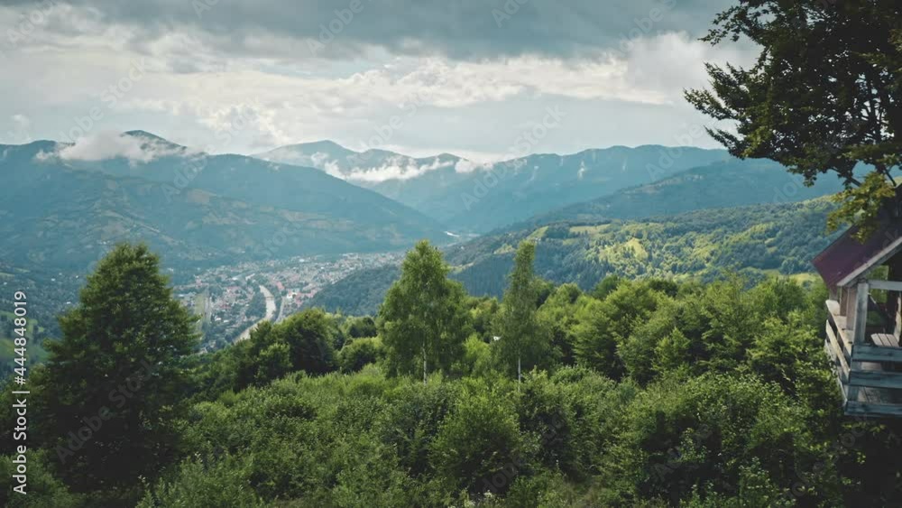 Aerial view, wooden treehouse on hillside in forest. Slow flight in summer over mountainous terrain in valley village. Dramatic sky with clouds. Eco tourism holidays in Chamonix, France. Aerial view, wooden treehouse on hillside in forest. Slow flight in summer over mountainous terrain in valley village. Dramatic sky with clouds. Eco tourism holidays in Chamonix, France.