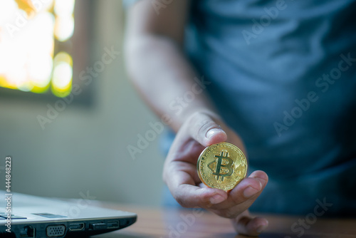 Businessman's hand holding a gold Bitcoin. Make money with bitcoin, digital currency money investment concept, blockchain transfer.