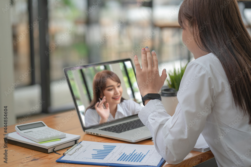 Back view of businesswoman speak using Webcam conference on a laptop with her friend Back view of businesswoman speak using Webcam conference on a laptop with her friend