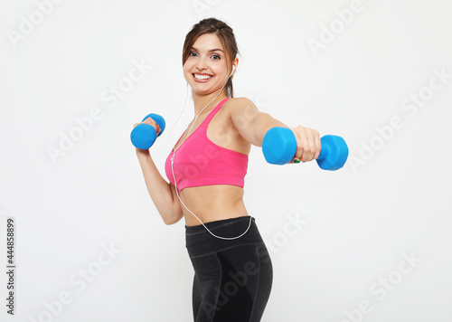 Picture of fit and healthy young woman smiling and holding dumbbelsl to shoulder. Sport and people concept.