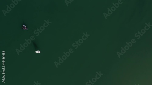 dinghy boat laser olimpic in bay with green wather and other boat photo