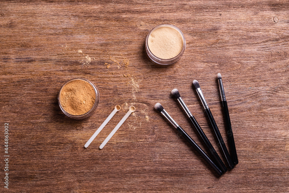 Mineral powder foundation with brushes on a wooden background. Eco-friendly and organic beauty products Mineral powder foundation with brushes on a wooden background. Eco-friendly and organic beauty products
