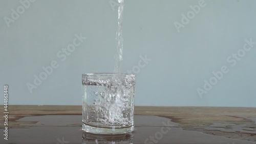 slow motion of pouring water into low-cut glass. Full HD