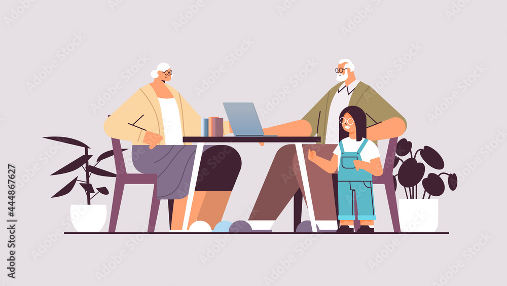 grandparents with granddaughter using laptop social media network online communication concept