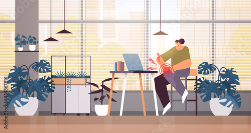 businesswoman at workplace suffering from knee pain inflammation of muscles concept