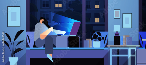 overworked businesswoman freelancer looking at computer screen girl sitting on bed in dark night home room