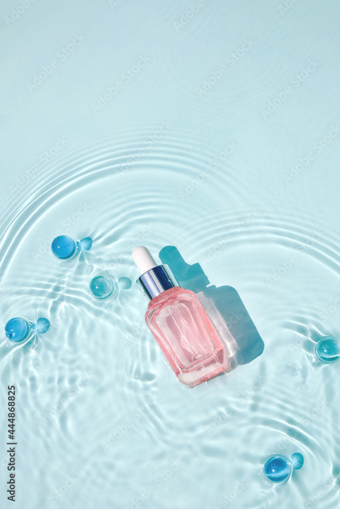 Mockup of cosmetic glass pink bottle with pipette and serum on water surface with waves Mockup of cosmetic glass pink bottle with pipette and serum on water surface with waves