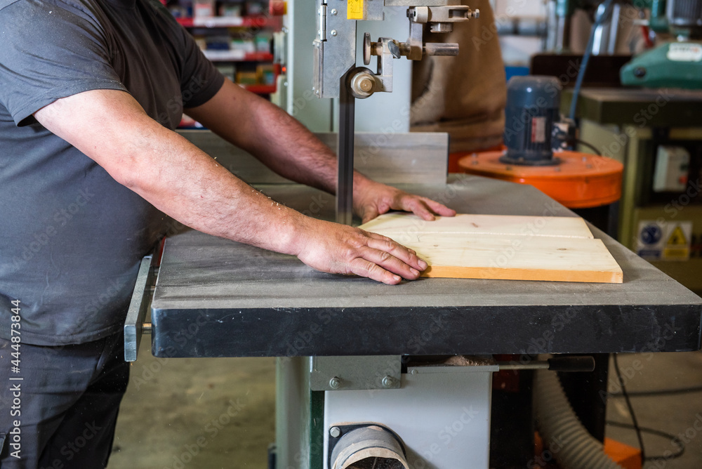 hands of a man cutting a wooden board in two on a machine in a carpentry workshop to be processed, ecological wood, hands of a man cutting a wooden board in two on a machine in a carpentry workshop to be processed, ecological wood,