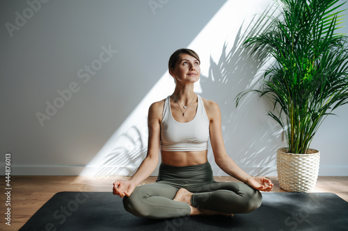 Obraz na plátně Joyful woman practicing yoga, meditating in a big studio