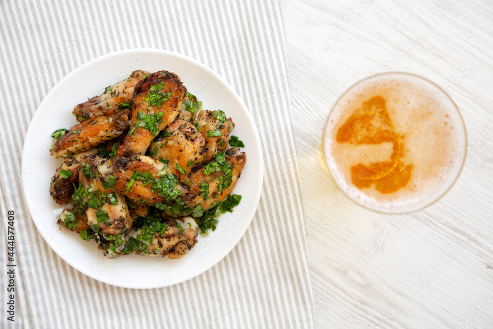 Homemade baked Garlic Parmesan Chicken Wings with Cold Beer, top view. Flat lay, overhead, from above. Homemade baked Garlic Parmesan Chicken Wings with Cold Beer, top view. Flat lay, overhead, from above.