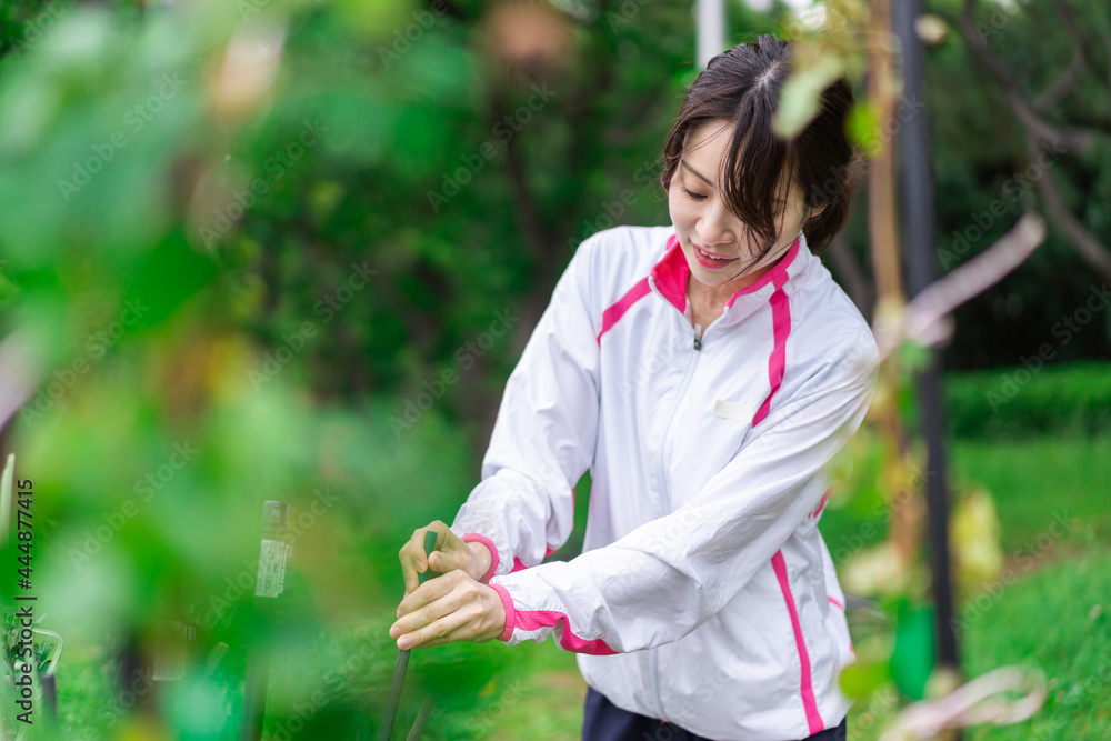 庭で花の世話をする若い女性