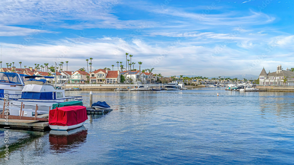 Pano Houses and docks along sea viewed from the sandy shore in Huntington Beach CA