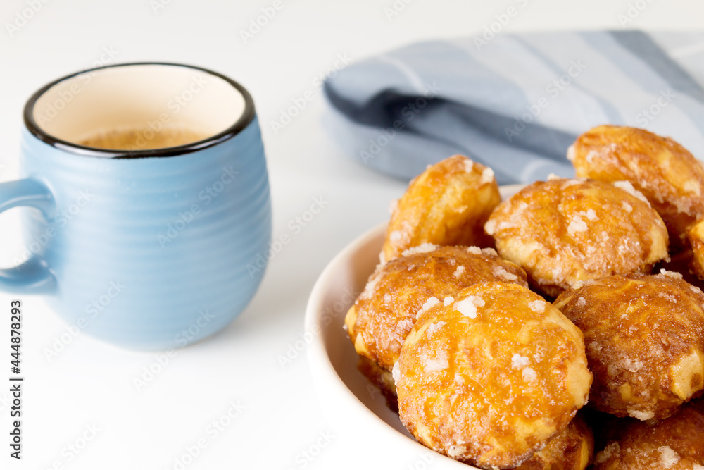 french chouquettes puffs with perles of sugar on plate with blue cup of coffee. Choux pastry Classic French bakeries. 